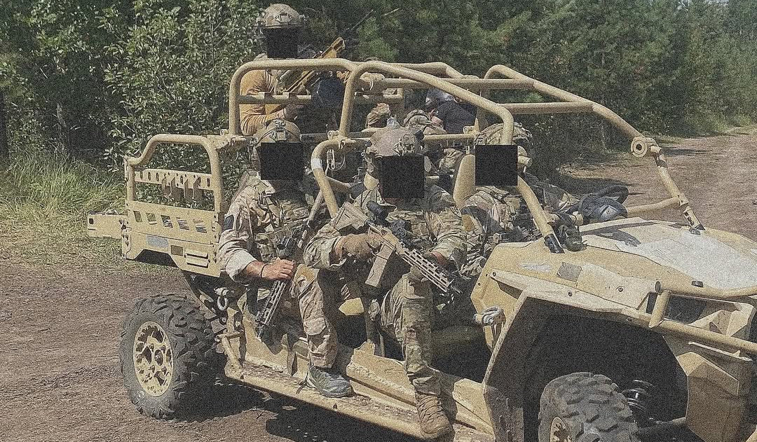 Military vehicle with soldiers in a forested area